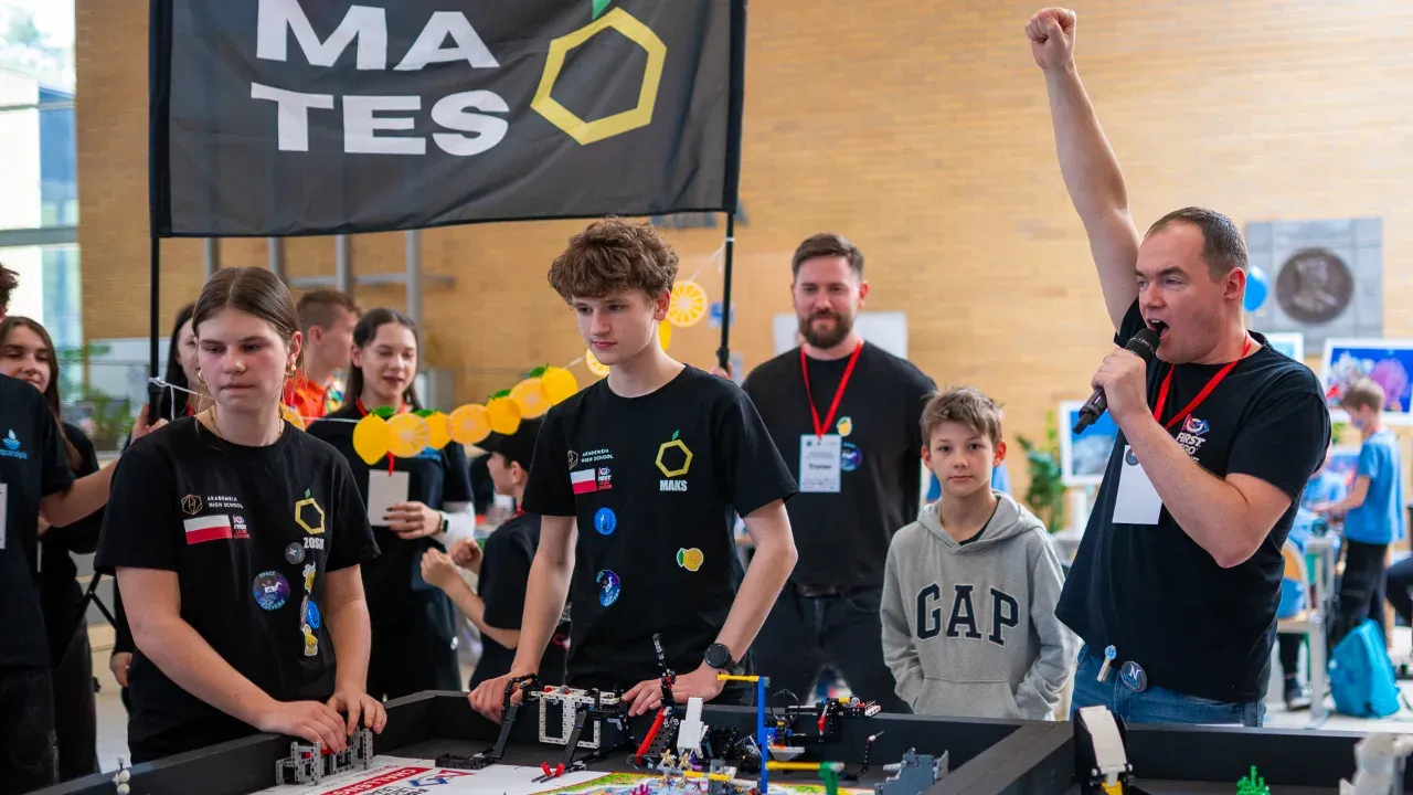 Trener i drużyna FIRST LEGO League przy macie turniejowej — emocje podczas Robot Game